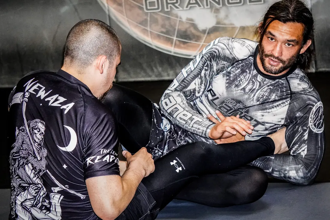 Coach demonstrating a no-gi control position at 10th Planet Orange